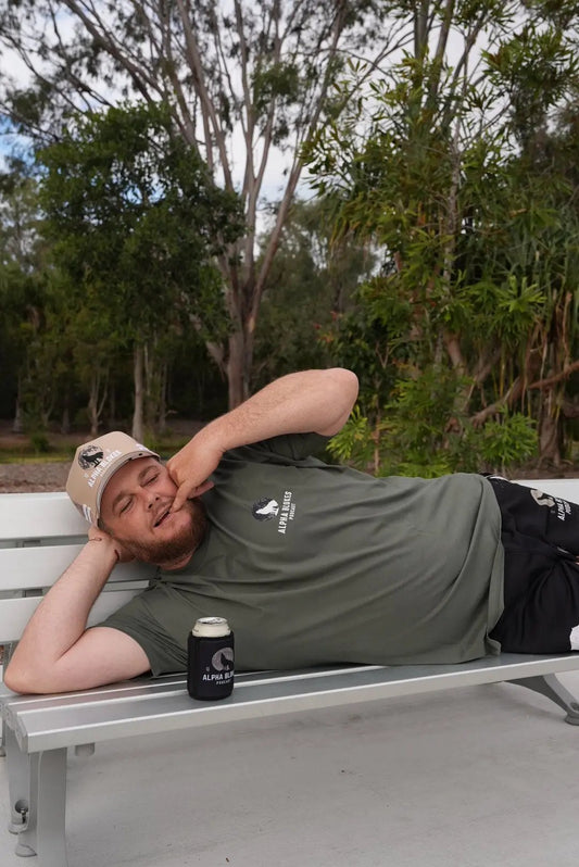 Person lying on a bench with trees in the background