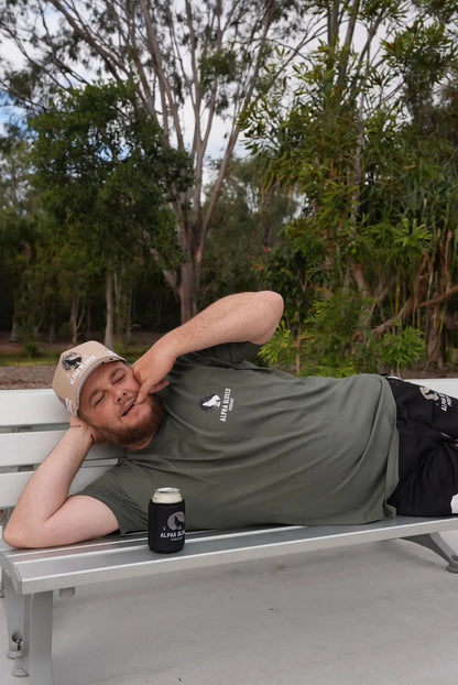 Person lying on a bench with trees in the background