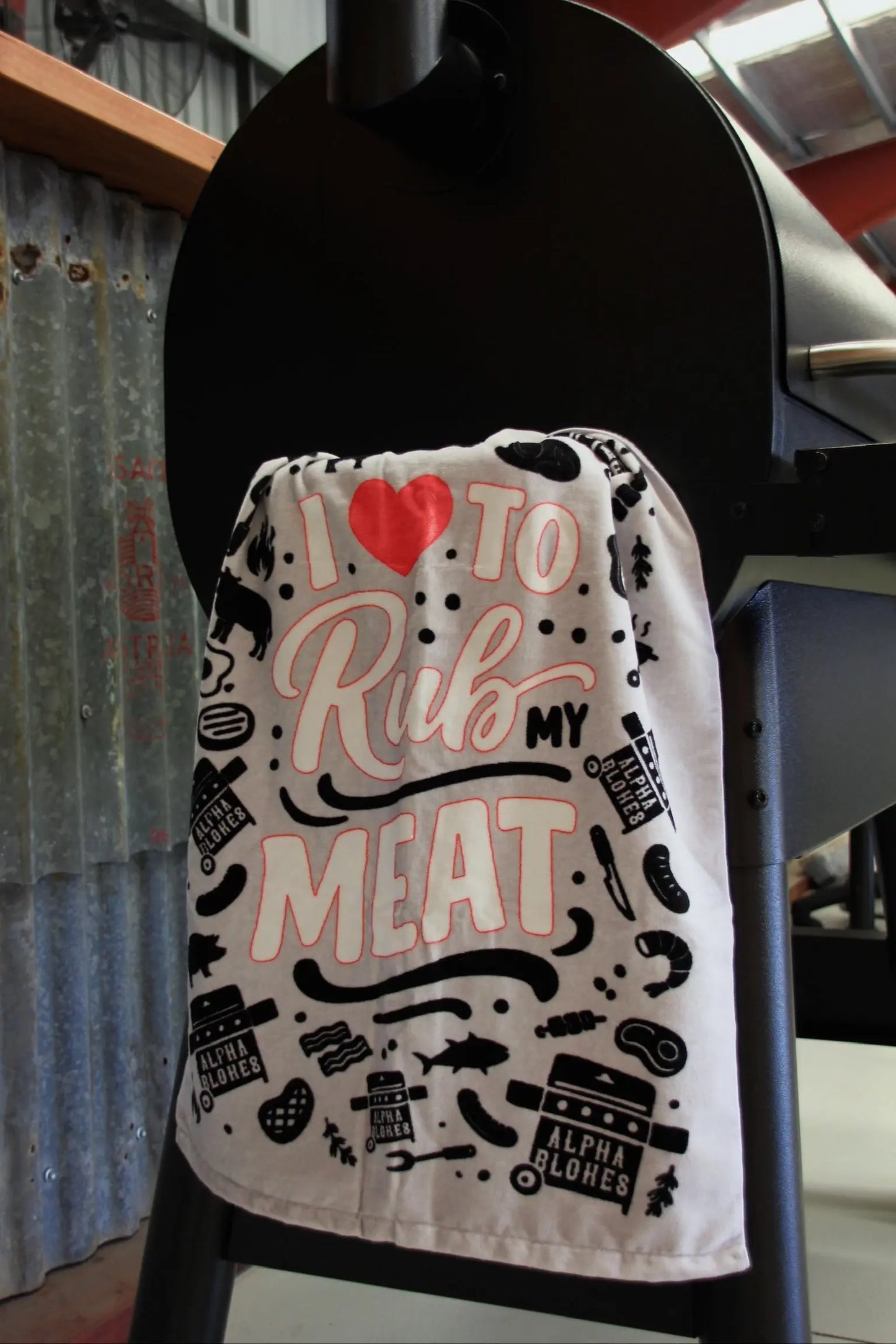 Towel with text and graphics hanging on a black stand