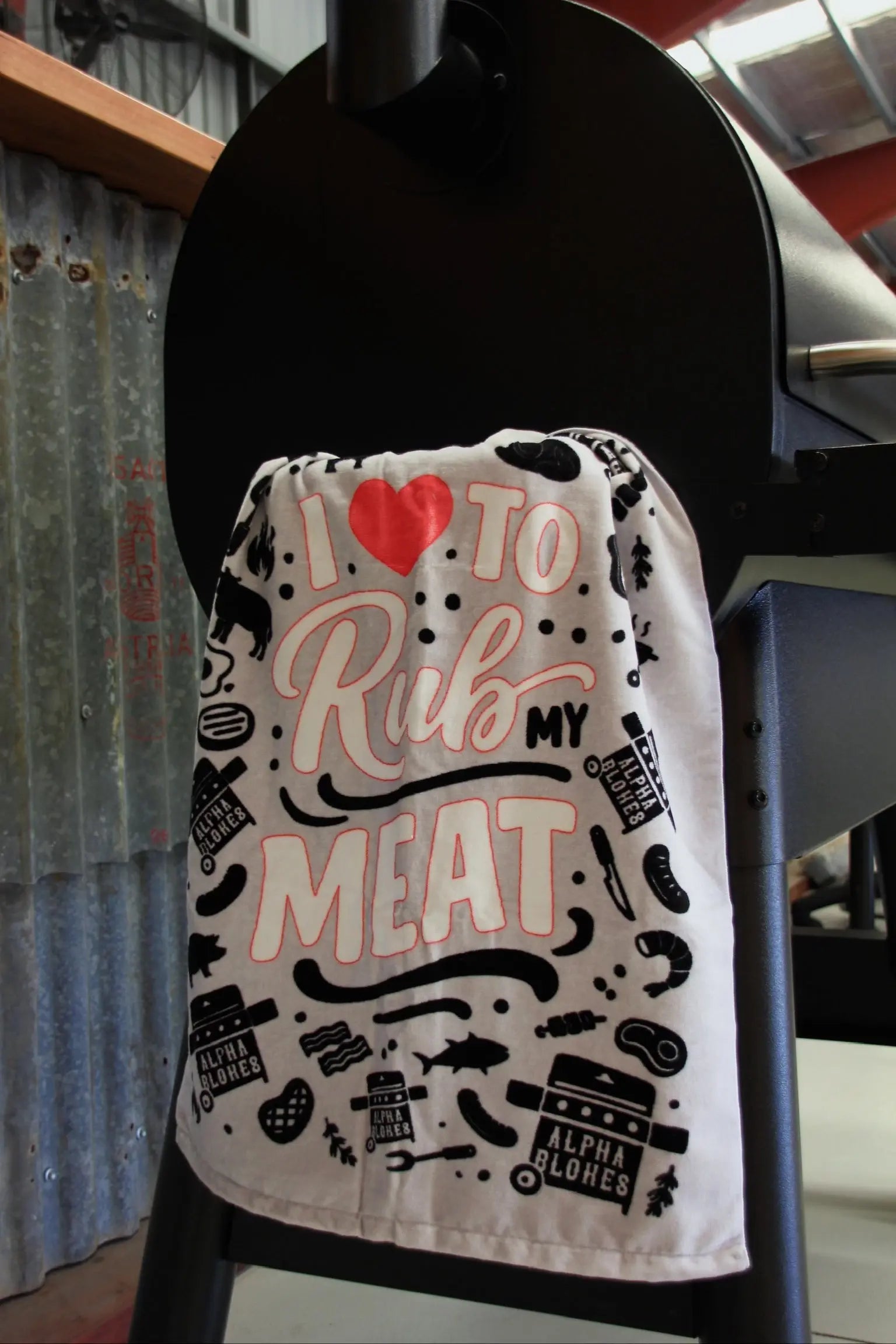 Towel with text and graphics hanging on a black stand