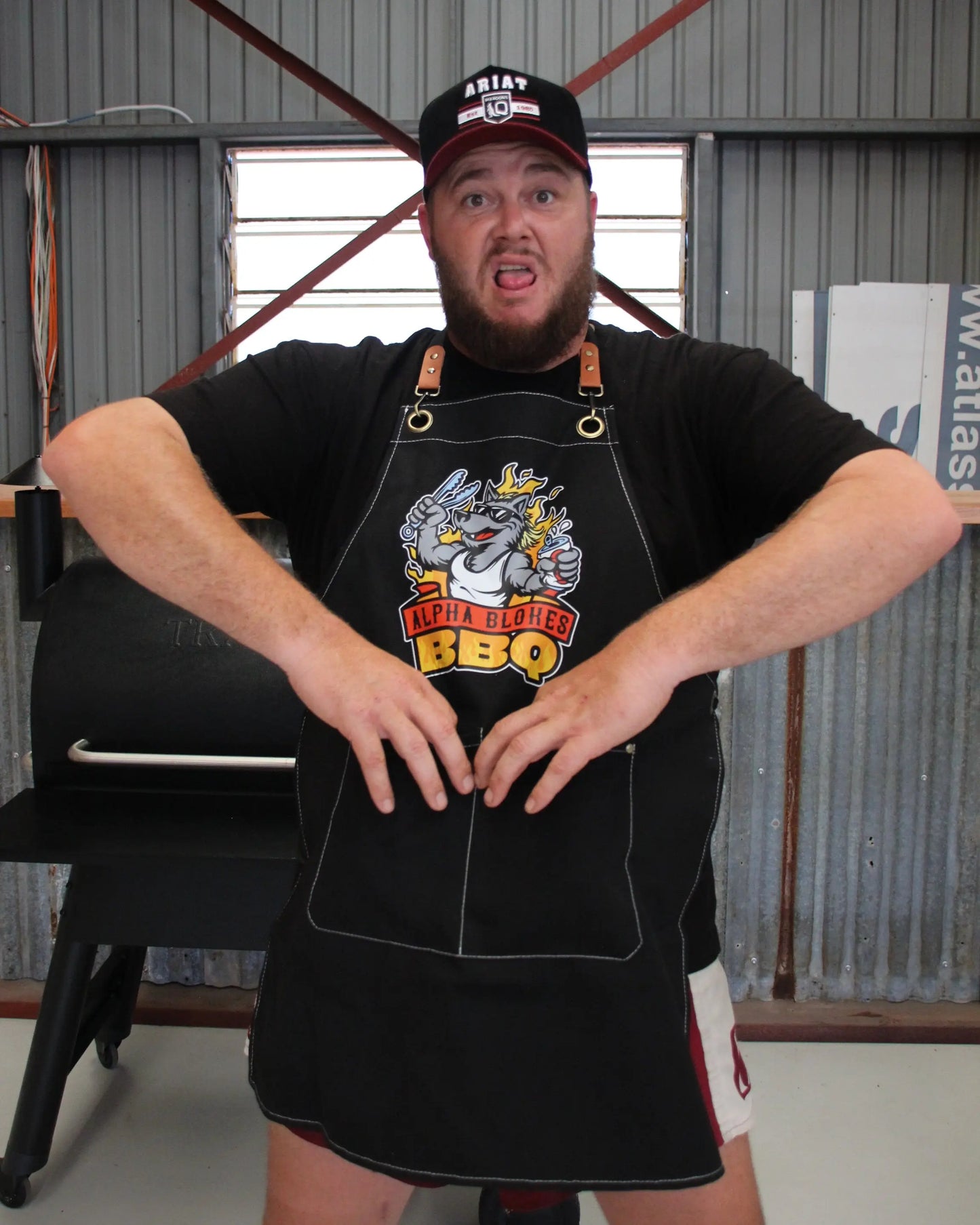 Man wearing a black apron with a graphic design in an industrial setting