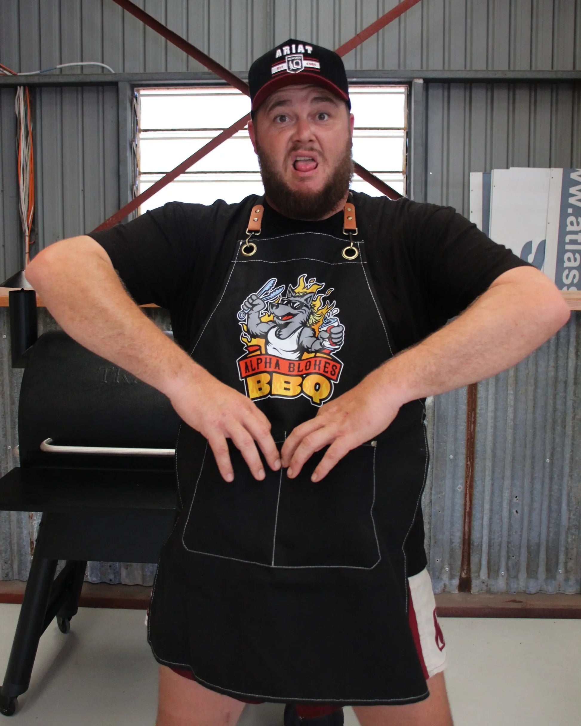 Man wearing a black apron with a graphic design in an industrial setting