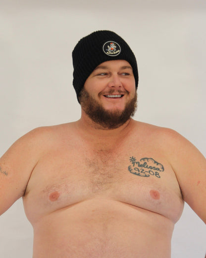 Man wearing a black beanie with a logo on a plain background