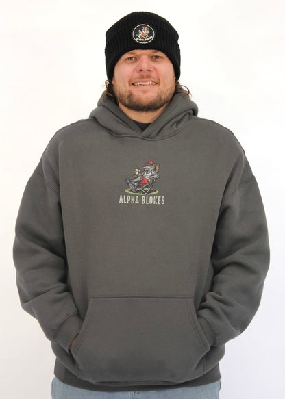 Man wearing a gray hoodie with a logo and text, standing against a white background